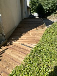 Rampe d’accès en bois, sécurisée et intégrée au jardin.