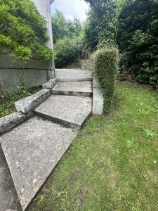 Rampe d’accès extérieure en béton, intégrée au jardin